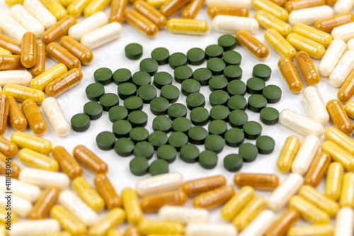 Chlorella pills and vitamin supplemets on white background photo