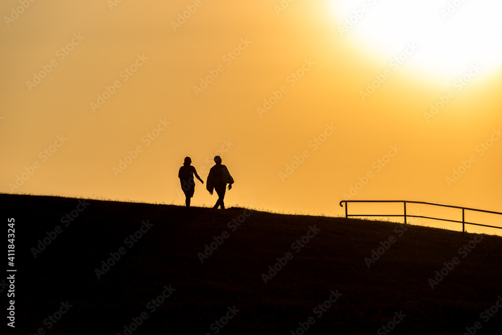 Tourists in the evening light on the dike in Cuxhaven
