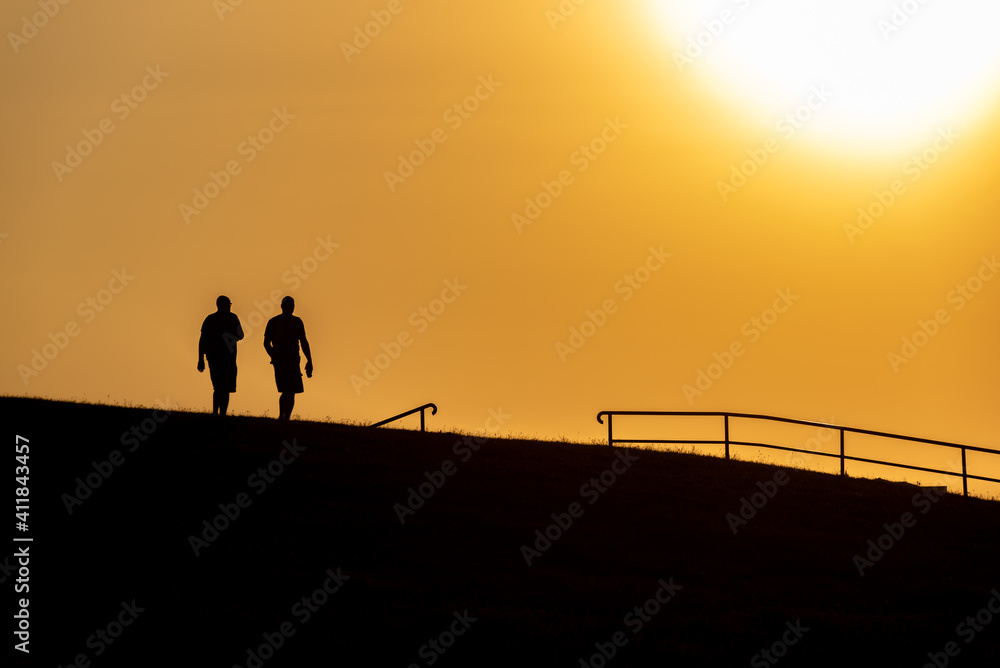 Tourists in the evening light on the dike in Cuxhaven