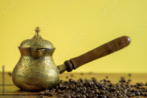 Coffee beans and vintage turkish coffee pot on wooden table