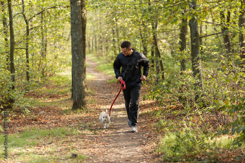 Sport Man runningon in forest with pet. Healthy active man jogging with dog © splitov27