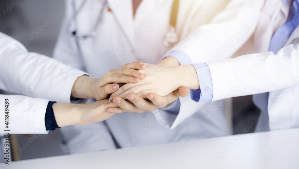 Group of modern doctors joining hands as a circle. Teamwork in medicine during Coronavirus pandemic, covid 2019 Group of modern doctors joining hands as a circle. Teamwork in medicine during Coronavirus pandemic, covid 2019