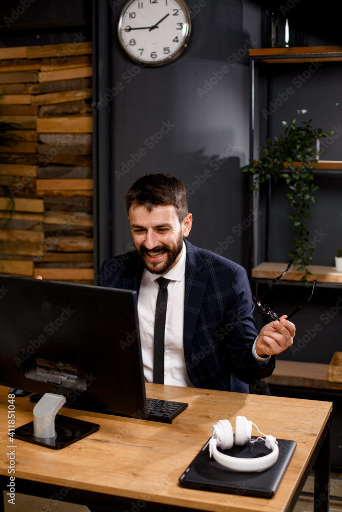 Young businessman working on computer at office. Businessman sitting at office desk working on new project Young businessman working on computer at office. Businessman sitting at office desk working on new project