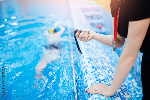 Quadro su tela Swimming instructor coach people, woman hold in hand stopwatch during competitio