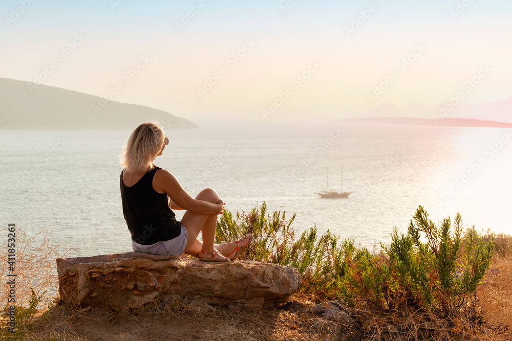 Happy Carefree Woman Enjoying Beautiful Sunset on the Shore. Summer Holiday Concept.