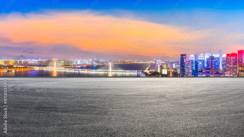 Race track road and modern city skyline with buildings in Hangzhou at night. Race track road and modern city skyline with buildings in Hangzhou at night.