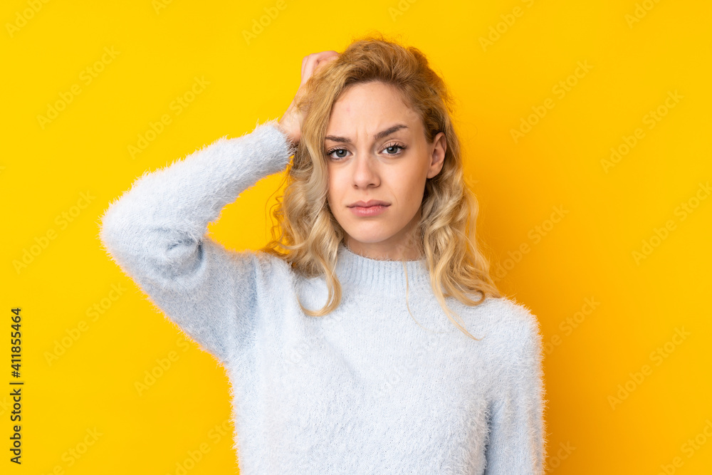 Young blonde woman isolated on yellow background with an expression of frustration and not understanding Young blonde woman isolated on yellow background with an expression of frustration and not understanding