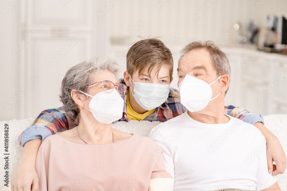 Family during the coronavirus pandemic. Old people in medical masks communicate with a child at home