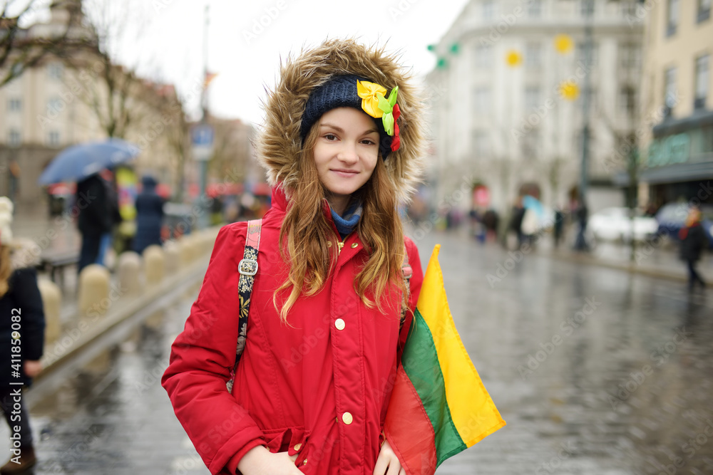 Cute young girl celebrating Lithuanian Independence Day holding Lithuanian flag in Vilnius, Lithuania Cute young girl celebrating Lithuanian Independence Day holding Lithuanian flag in Vilnius, Lithuania