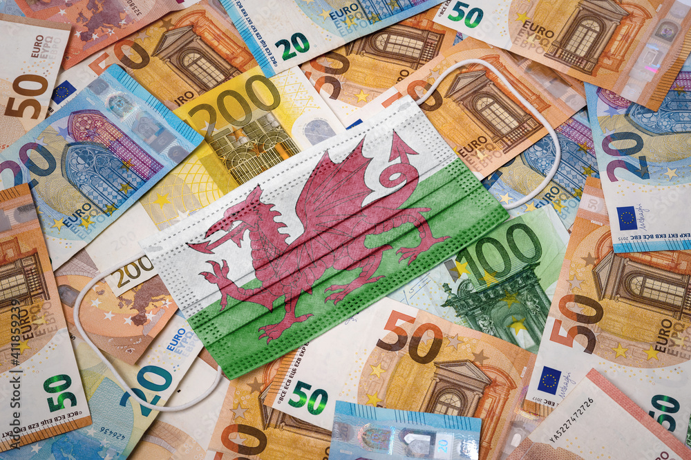 Medical mask with the flag of Wales on a variety of european banknotes.(series) Medical mask with the flag of Wales on a variety of european banknotes.(series)