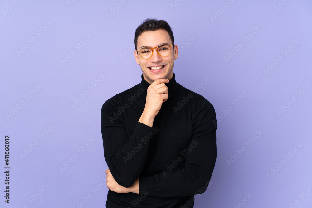 Young caucasian handsome man with turtleneck sweater isolated on purple background with glasses and smiling Young caucasian handsome man with turtleneck sweater isolated on purple background with glasses and smiling