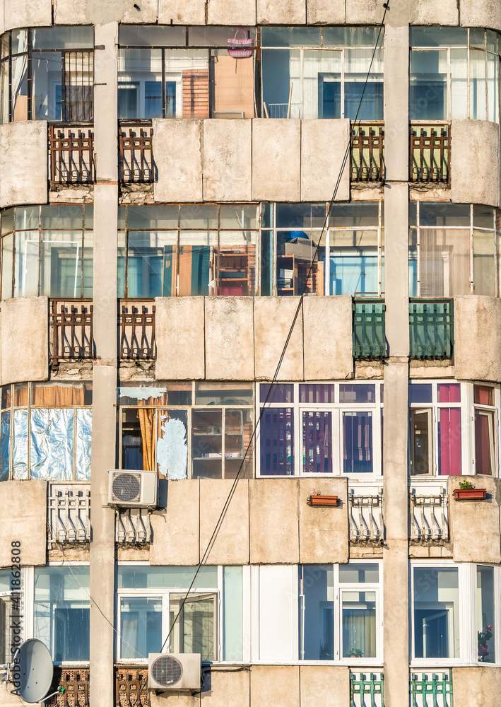 Worn out apartment building from the communist era against blue sky in