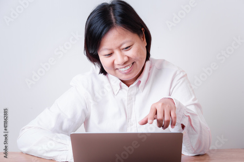 Happy business woman using computer looking at screen working in internet sit at office desk, smiling female professional employee typing email on laptop at workplace business concept.