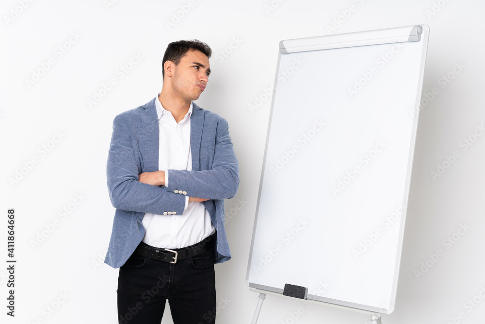Young caucasian handsome man isolated on purple background giving a presentation on white board and making doubts gesture Young caucasian handsome man isolated on purple background giving a presentation on white board and making doubts gesture