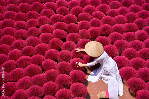 Woman gathering dried Incense sticks, Hanoi, Vietnam