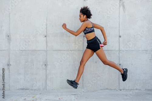 Afro athletic woman running outdoors.