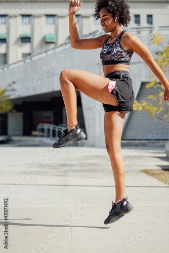 Afro athletic woman doing exercise outdoors.
