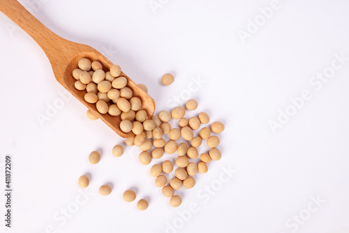 Soya bean in wooden scoop spoon on white background