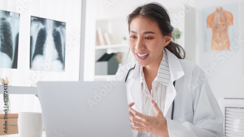 Asian female doctor using laptop computer online video call remote talking to patient, prescribe medicine. Tele medical, telehealth, hospital clinic health care service, or internet technology concept