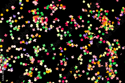 directly above view of colorful paper confetti isolated on black background