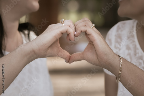 Same sex couple holding hands in heart shape