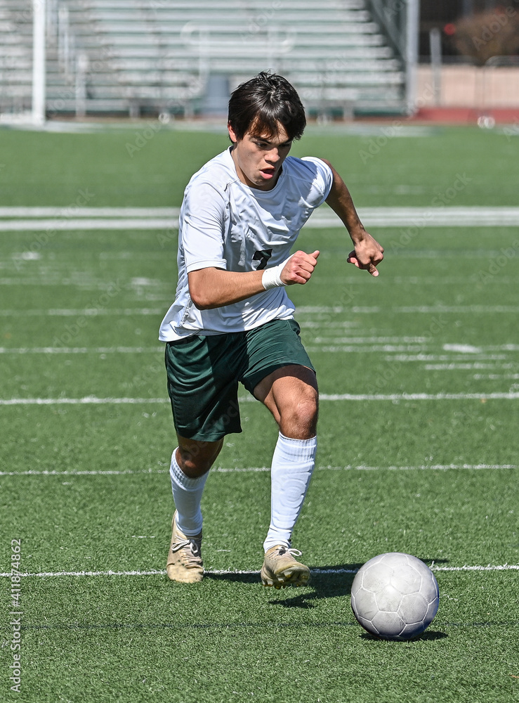 Young Athletic boy kicking the ball during a soccer game Young Athletic boy kicking the ball during a soccer game