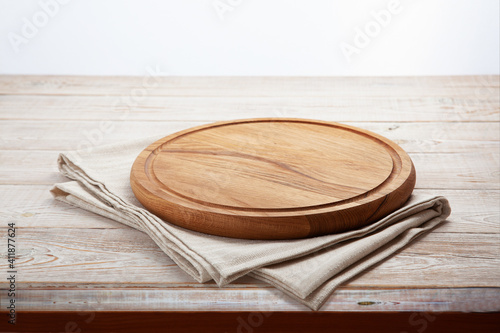 Empty pizza board and napkin on white wooden perspective, mockup