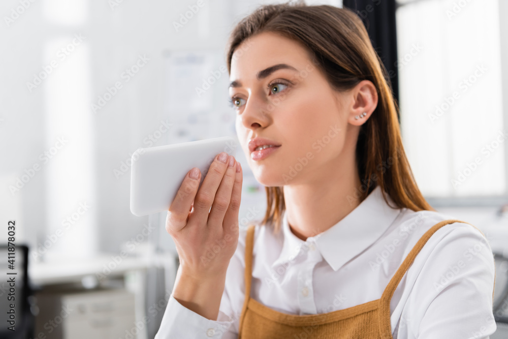 Smartphone in hand of young businesswoman in office Smartphone in hand of young businesswoman in office
