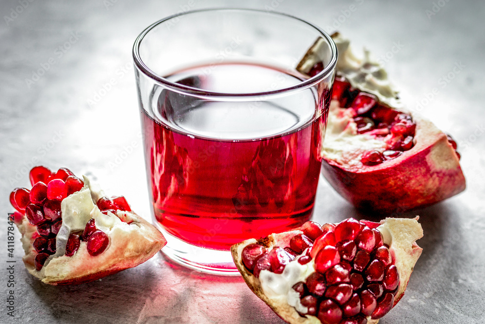 pomegranate juice with seed on stone table background pomegranate juice with seed on stone table background