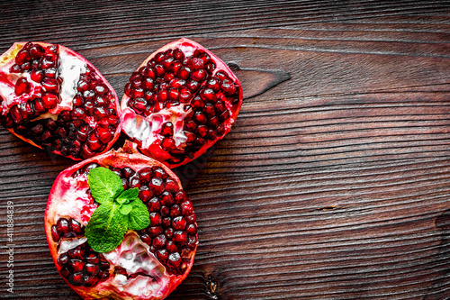 sliced pomegranate on wooden background top view