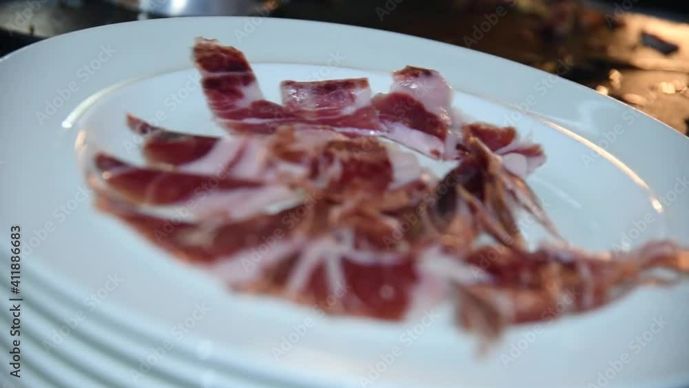 A chef cutting and serving Serrano ham on a plate. Cutting serrano ham A chef cutting and serving Serrano ham on a plate. Cutting serrano ham
