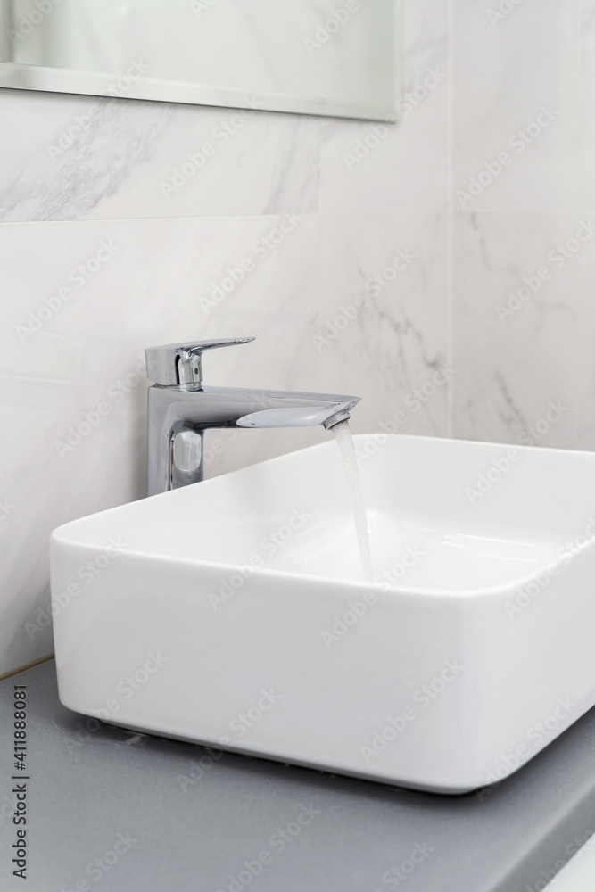 Fototapeta premium Sink and water tap near tiled bathroom wall