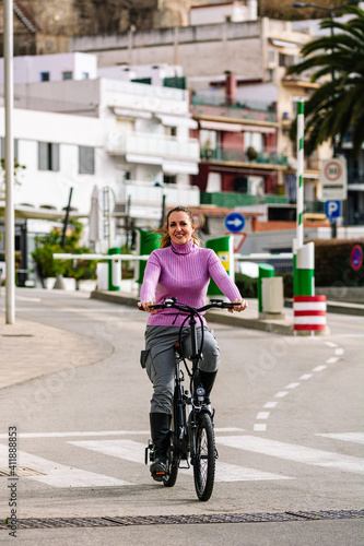 Wallpaper Mural 40-year-old woman riding her electric bicycle through the streets of the city Torontodigital.ca