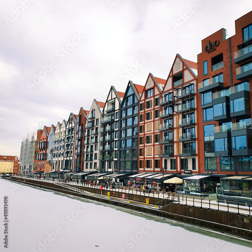 Beautiful colorful townhouses on the banks of the frozen Motlawa River in Gdansk, Poland