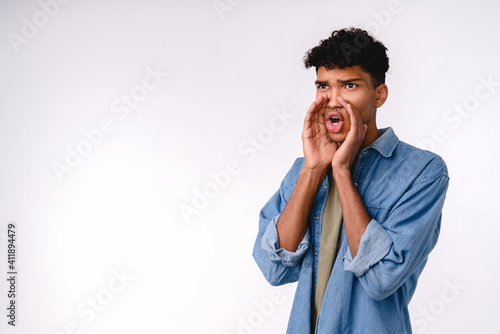 Handsome young african man announcing with the hand to make it louder isolated over white background