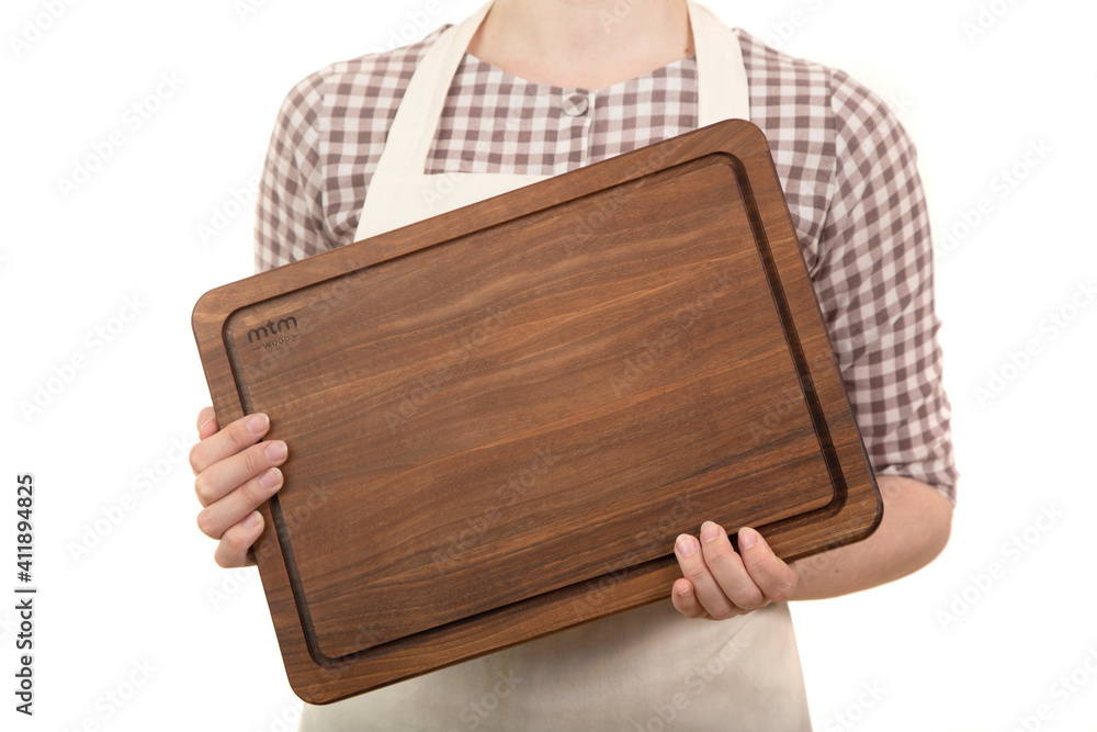 The hands of a culinary man are holding a wooden cutting board.