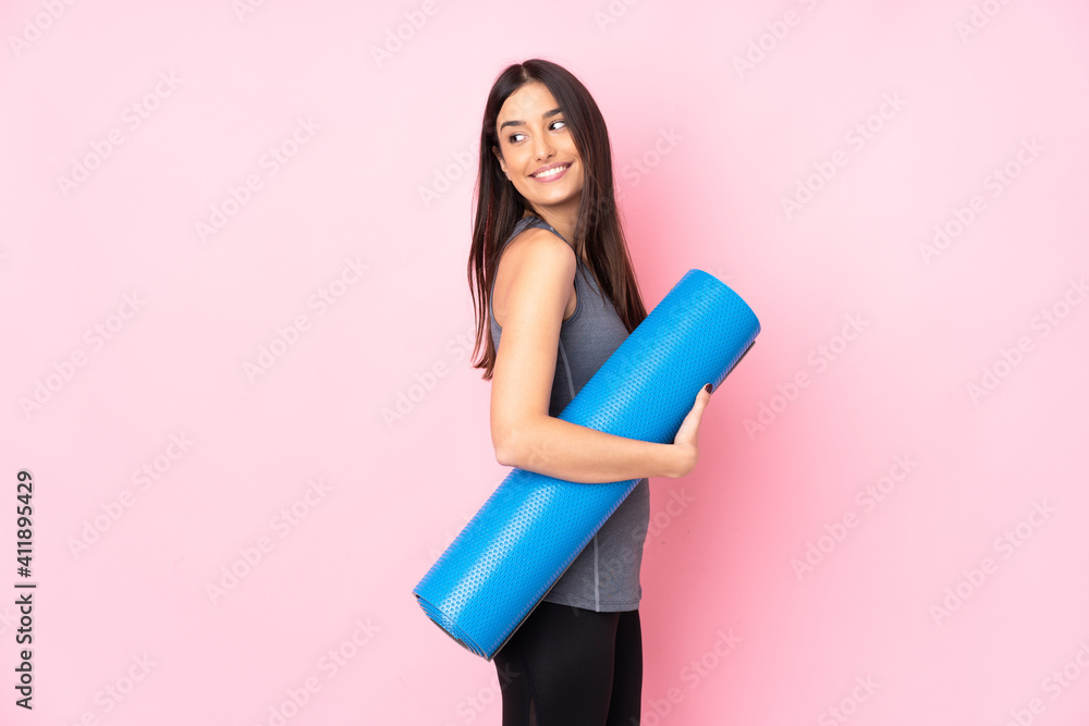 Young caucasian woman with mat isolated on pink background laughing Young caucasian woman with mat isolated on pink background laughing