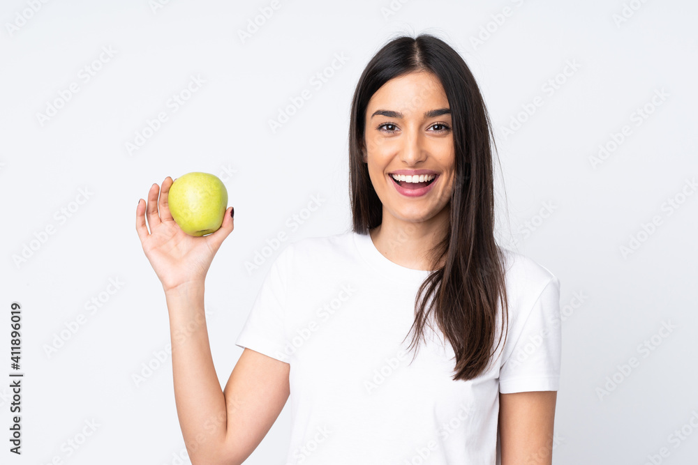Young caucasian woman isolated on white background with an apple and happy Young caucasian woman isolated on white background with an apple and happy
