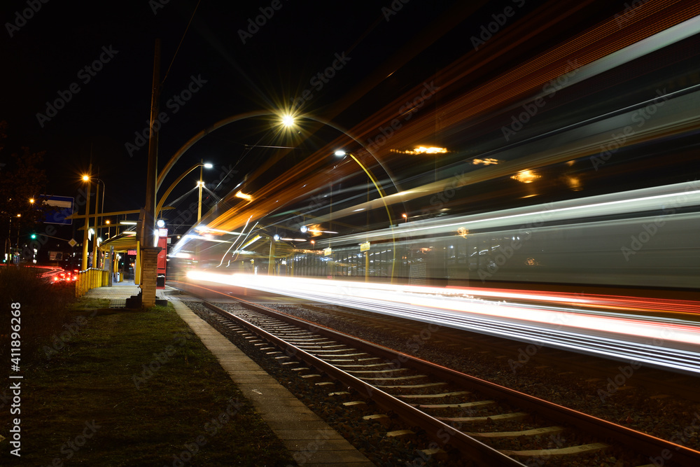 Tram at night, blurred traffic, tram stop