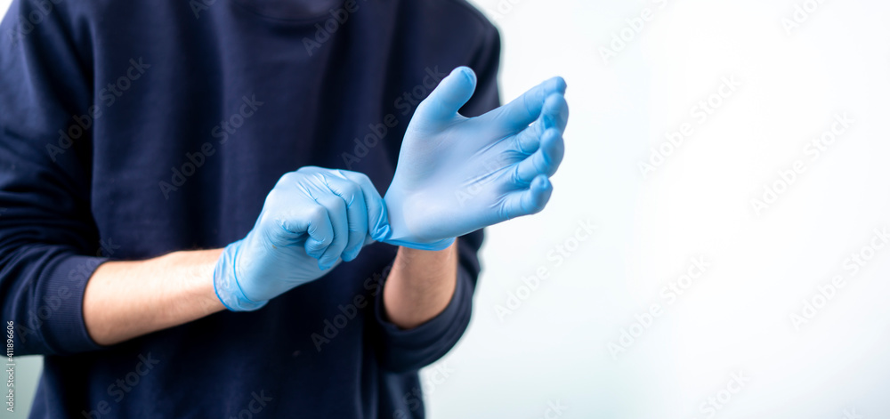 close up person try to put on protective gloves on hands to protect from the coronavidus epidemic