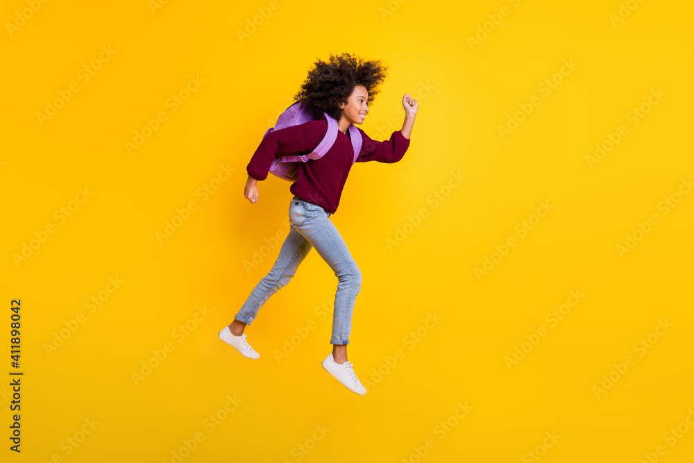 Full body profile photo of wavy dark skin girl running carry rucksack wear sweater isolated on yellow color background