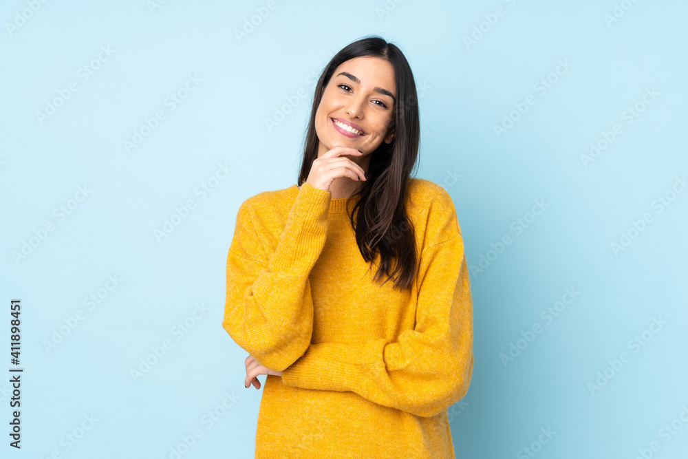 © luismolinero - Young caucasian woman isolated on blue background happy and smiling