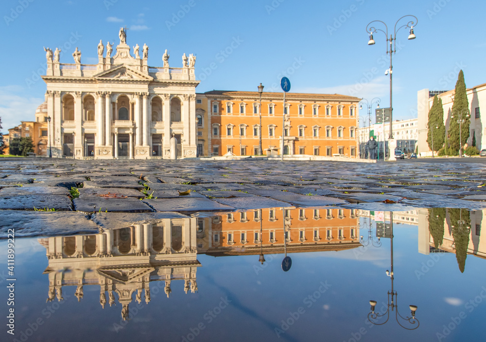 Rome, Italy - in Winter time, frequent rain showers create pools in which the wonderful Old Town of Rome reflects like in a mirror. Here in particular the San Giovanni Basilica 