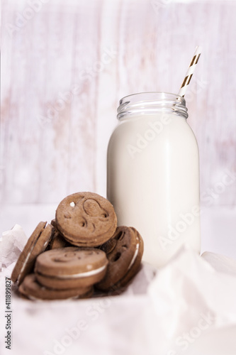 Fotografiet Vertical shot of a jar with almond milk and cookies on table