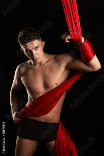 aesthetics of the body, gymnast with red cloth, gymnast on a black background