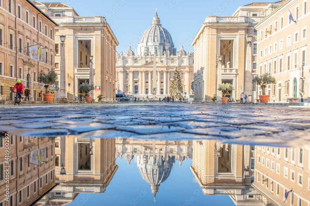 Fototapeta premium Rome, Italy - in Winter time, frequent rain showers create pools in which the wonderful Old Town of Rome reflects like in a mirror. Here in particular the St. Peter's Basilica 