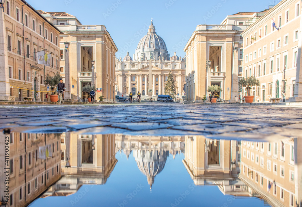 Rome, Italy - in Winter time, frequent rain showers create pools in which the wonderful Old Town of Rome reflects like in a mirror. Here in particular the St. Peter's Basilica 