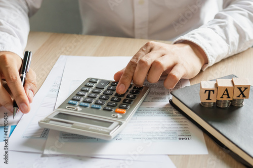 Close up hand of stress young asian businessman,male is pressing a calculator to calculate tax income and expenses, bills, credit card for payment or payday at home, office.Financial, finance concept.