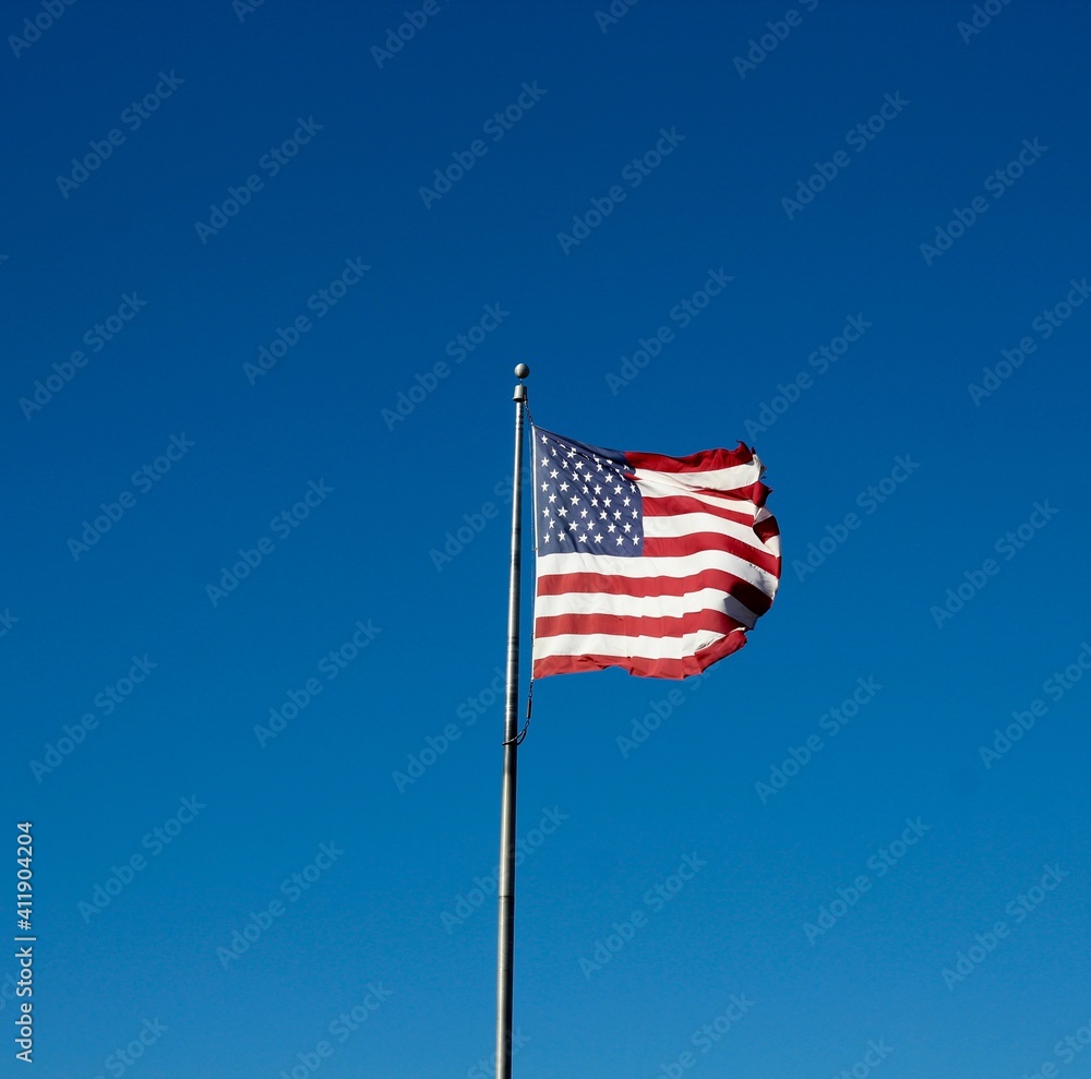 The america flag with the bright blue sky background.