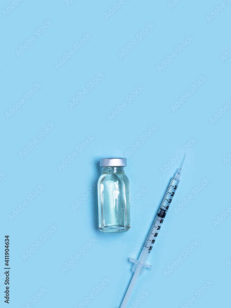 Syringe with medicine from glass vial on light blue background. Vaccination against influenza, covid 19, measles, coronavirus disease. Vaccination and immunization concept Syringe with medicine from glass vial on light blue background. Vaccination against influenza, covid 19, measles, coronavirus disease. Vaccination and immunization concept